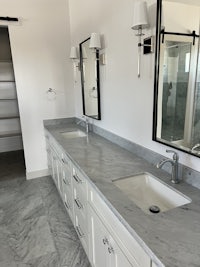 a bathroom with marble counter tops and sinks