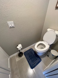 a small bathroom with a toilet and a blue rug