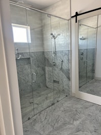 a bathroom with glass shower doors and a marble floor