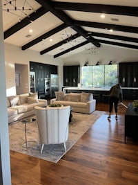 a living room with hardwood floors and black beams