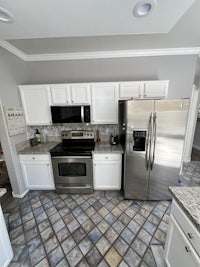 a kitchen with stainless steel appliances and tile floors