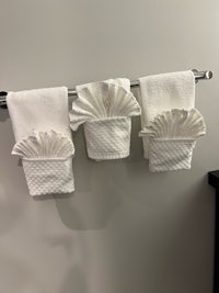 three towels hanging on a towel rack in a bathroom