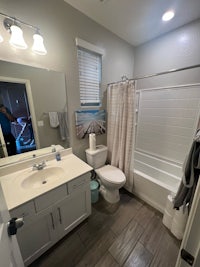 a bathroom with a toilet, shower, and sink